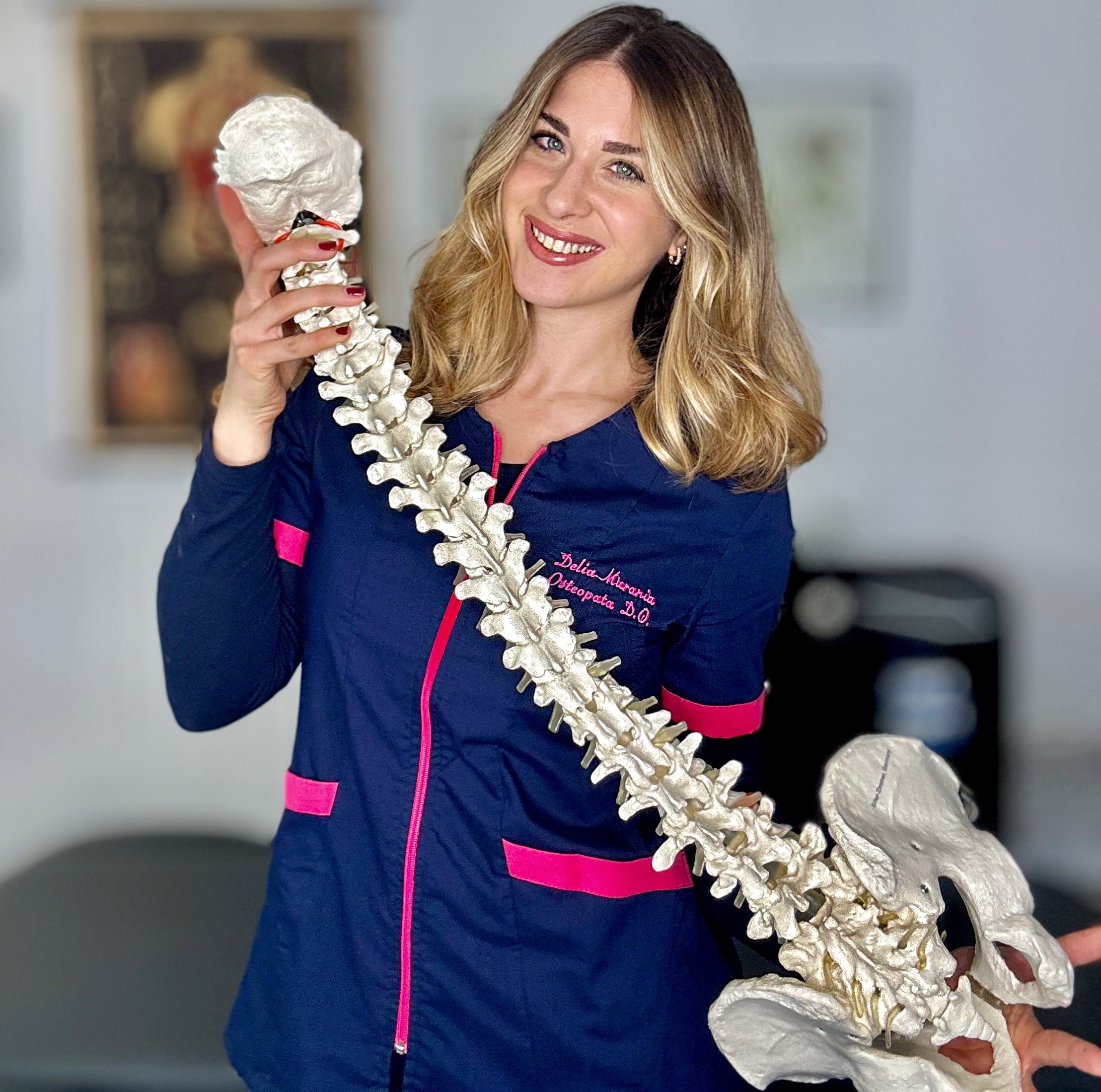 Delia Murania Osteopata con modello anatomico della colonna vertebrale